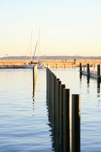 Wooden pier on sea against clear sky