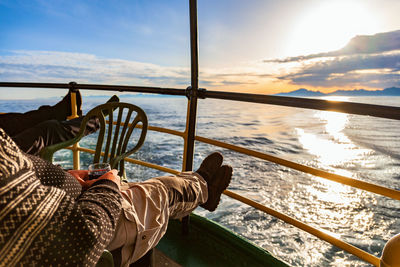 People drinking a glass of wine and enjoying the sunset on a cruise ship