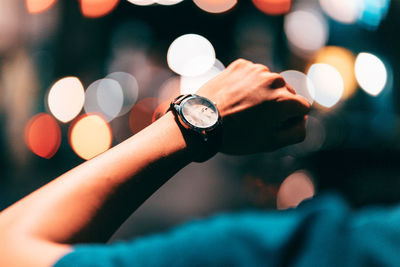 Close-up of hand holding illuminated clock