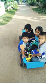 High angle view of siblings sitting on toy car