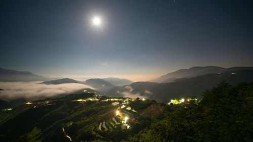 Scenic view of illuminated mountains against sky at night