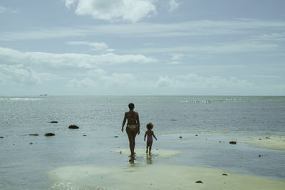 Children on beach against sky