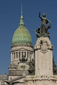 Low angle view of statue of building against clear sky