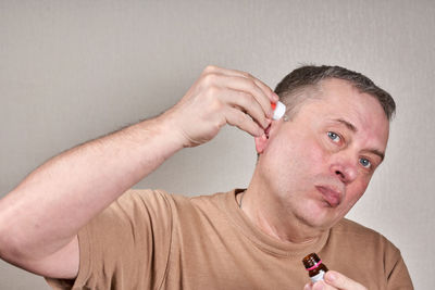 Close-up portrait of man against wall