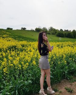 Full length of young woman standing on field