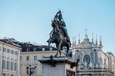 Low angle view of sculpture by church against clear sky at piazza san carlo