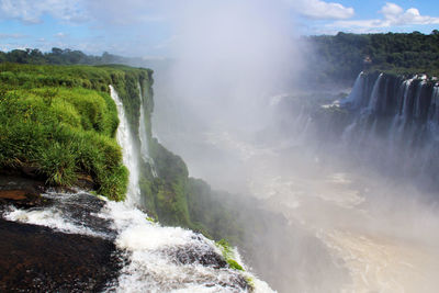 Scenic view of waterfall against sky