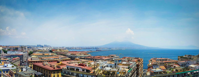 High angle view of buildings by sea against sky