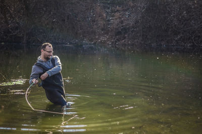 Man fishing in lake at forest