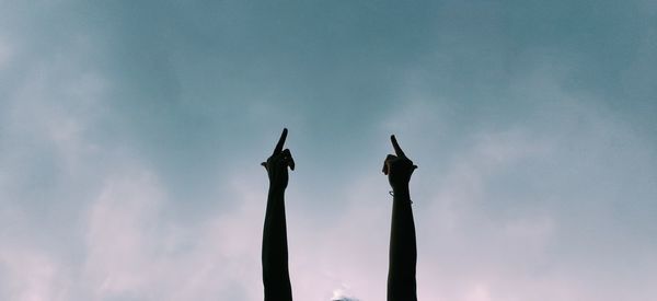 Low angle view of silhouette hand against sky