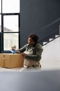 Side view of young woman sitting on table