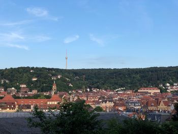 High angle view of buildings in town against blue sky