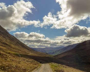 Scenic view of road amidst mountains against sky