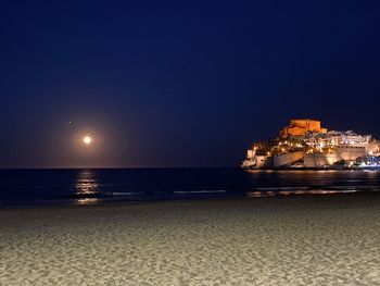Scenic view of sea against clear sky at night