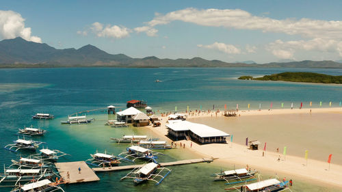 Beautiful beach on tropical island surrounded by coral reef, sandy bar with tourists. honda bay 