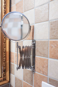 Close-up of mirror on tiled wall in bathroom