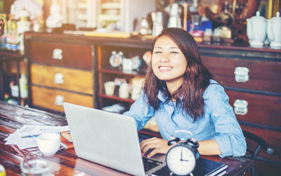 Portrait of smiling woman sitting at table