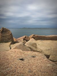 Rocks on beach against sky