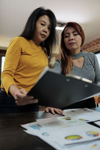 Female professionals making reports at office