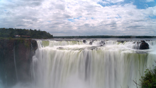 Scenic view of waterfall against sky