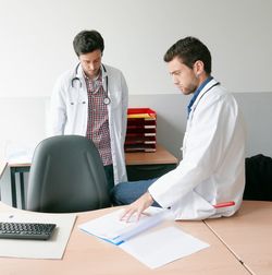 Doctors discussing patient report in hospital