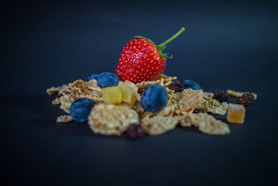 Close-up of fresh fruits in plate against black background