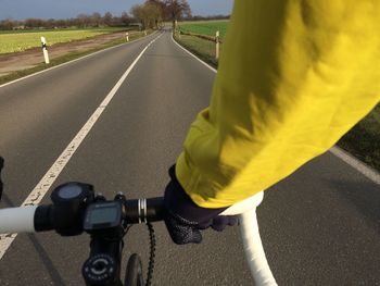 Cropped image of man riding bicycle on road