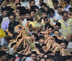 People carrying buddha statue during traditional festival