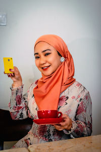 Portrait of smiling young woman using mobile phone