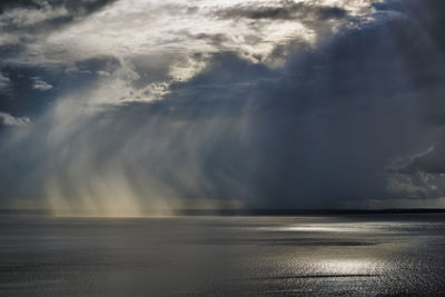 Scenic view of sea against storm clouds