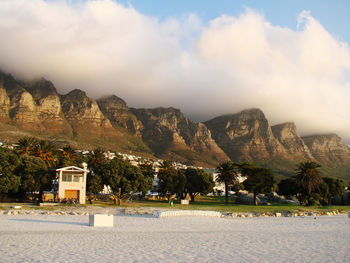 Scenic view of building by mountains against sky