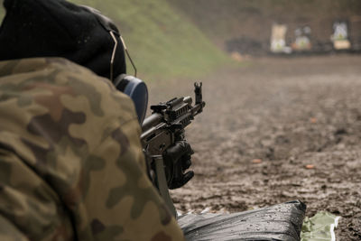Close-up of soldier aiming rifle