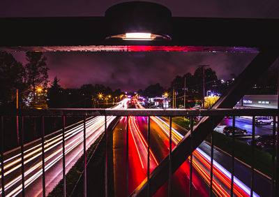 Light trails in city against sky at night