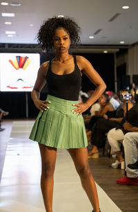 Portrait of young woman standing against wall