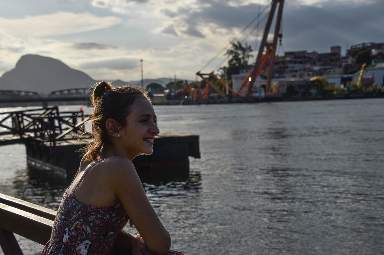 water, adults only, one woman only, happiness, one person, only women, vacations, sky, smiling, outdoors, people, cloud - sky, sea, harbor, day, adult, nautical vessel, beauty in nature, close-up