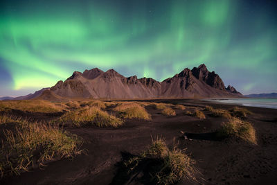 Scenic view of mountains against aurora borealis at night