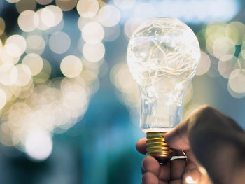 Close-up of hand holding light bulb