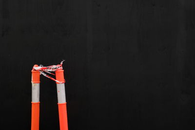 Close-up of traffic cones against black wall