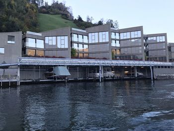 Buildings by river against sky