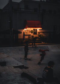 People walking on illuminated street at night