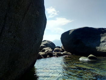 Rocks on sea shore against sky