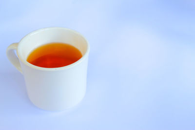 Close-up of tea cup against blue background
