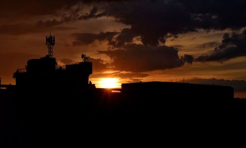 Silhouette city against sky during sunset