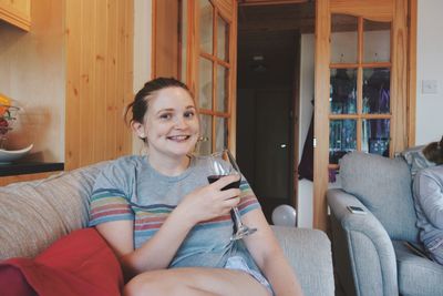 Portrait of happy boy sitting on sofa at home