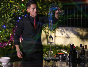 The bartender with a cocktail is preparing acocktail at the bar. barman making cocktail at nightclub