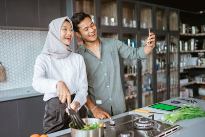 Portrait of smiling young woman standing in factory