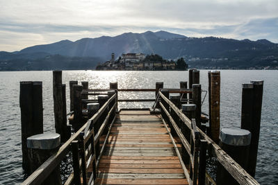Wooden pier over lake against sky