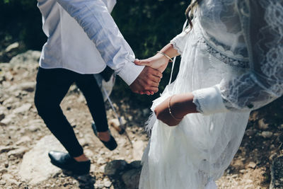 Midsection of couple holding hands