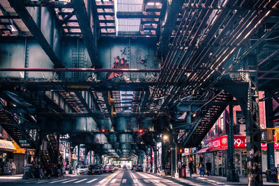 Illuminated road amidst buildings in city at night