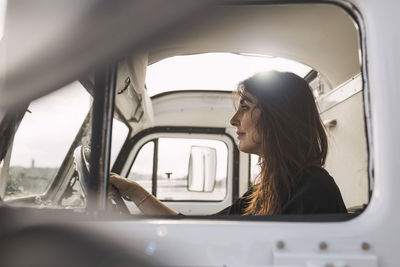 Side view of mature businesswoman driving portable office truck